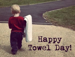 Toddler carrying blanket with caption Happy Towel Day!