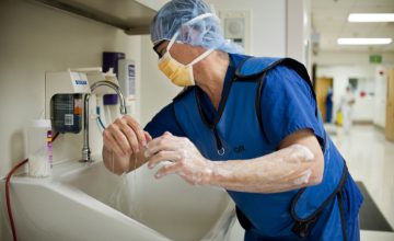 A surgeon scrubs his hands and arms before going into the operating room at Riverside County Regional Medical Center.